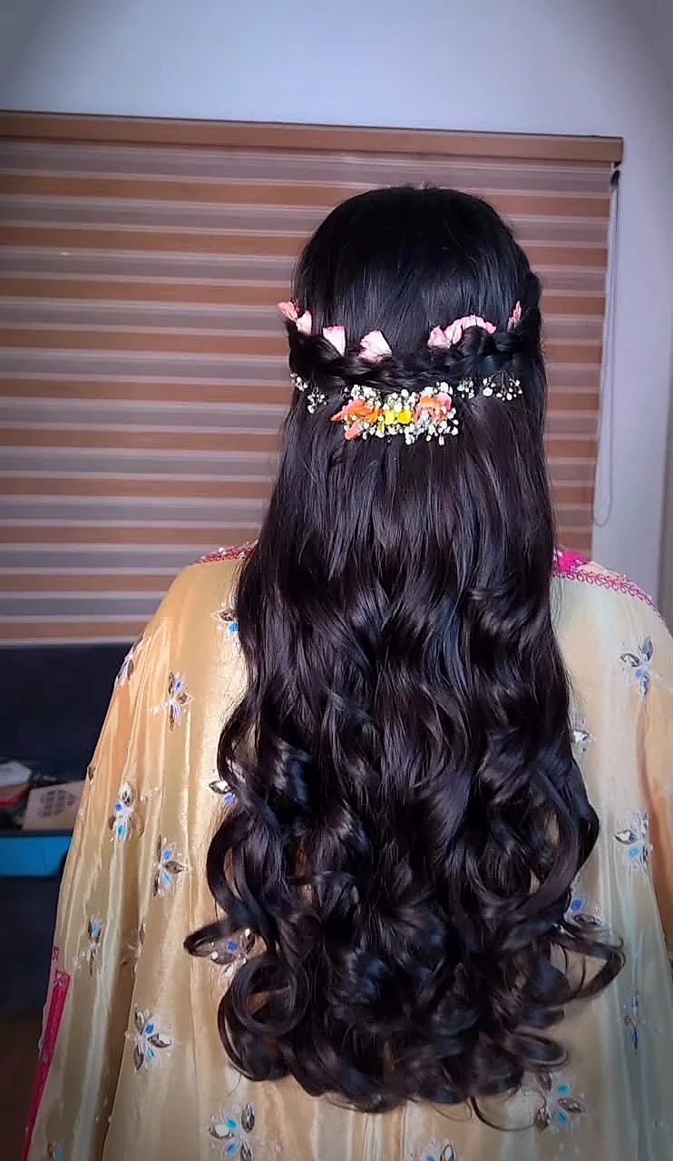 Crown braid woven with baby breath and fresh peach flower petals into cascading curls