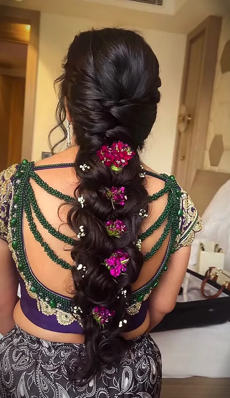 Intricate Indian bridal mermaid braid decorated with fresh purple flowers and baby breath